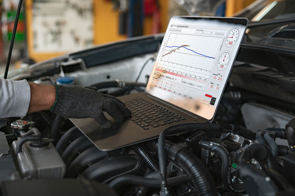 An image of a man working on a diagnostic on a car